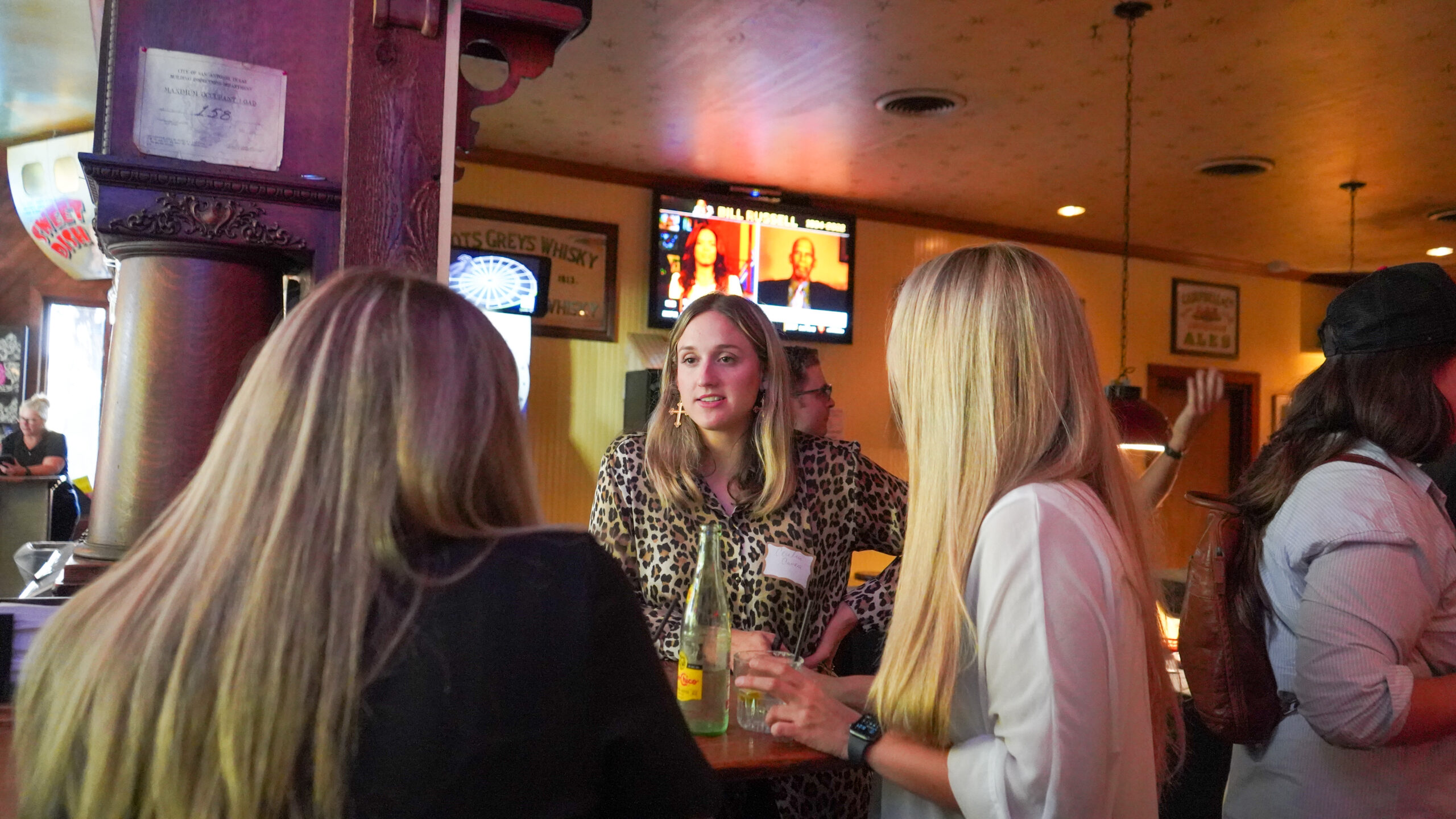 Attendees gather around the bar and chat